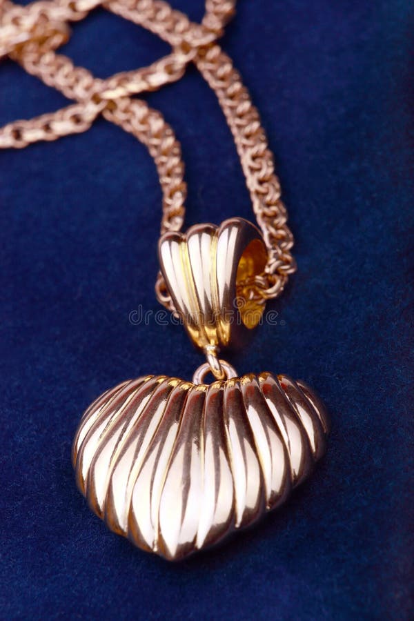 Collana dorata del cuore fotografia stock Collana dorata del cuore fotografia stock