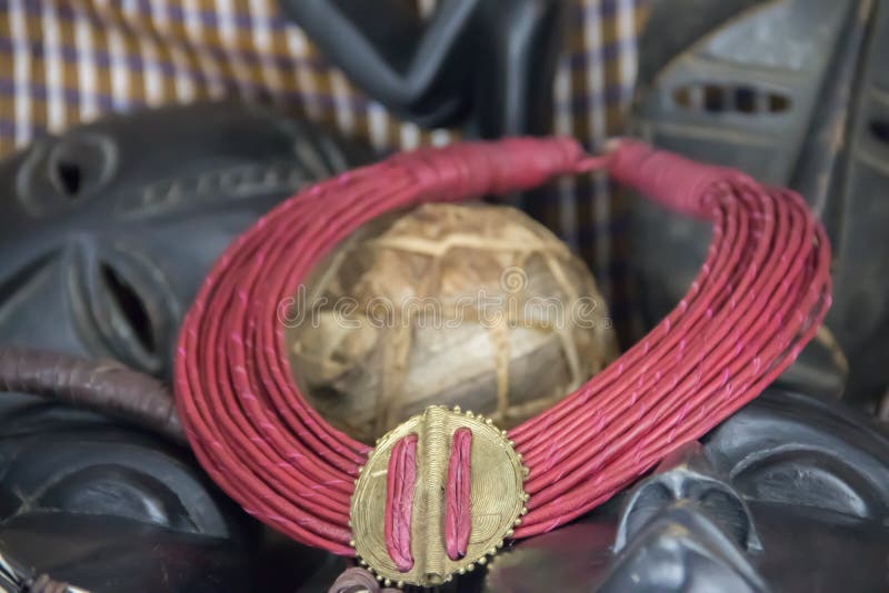 Collana tribale africana con fondo fatto dei manufatti africani immagini stock Collana tribale africana con fondo fatto dei manufatti africani immagini stock