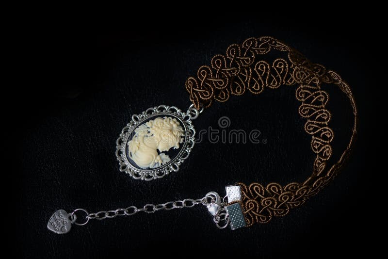 Collar de Brown con el camafeo de la muchacha en un fondo oscuro fotografía de archivo Collar de Brown con el camafeo de la muchacha en un fondo oscuro fotografía de archivo
