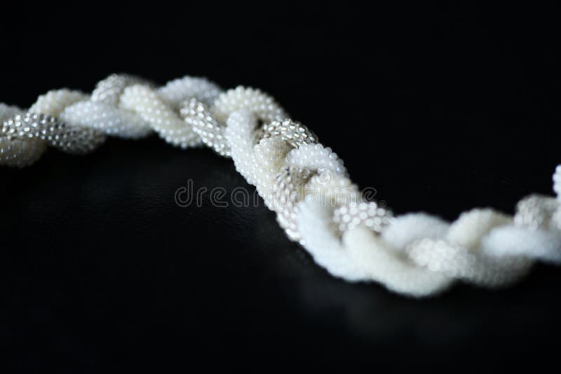 Collar moldeado en la forma de la trenza en un fondo oscuro fotos de archivo libres de regalías Collar moldeado en la forma de la trenza en un fondo oscuro fotos de archivo libres de regalías