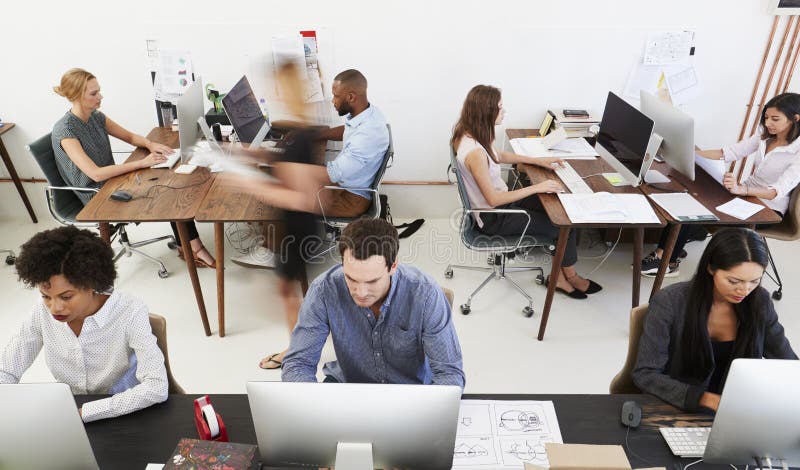 Colleagues at computers in an open plan office, front view stock photo Colleagues at computers in an open plan office, front view stock photo