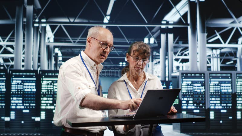 Colleagues crosschecking server parts stock photo