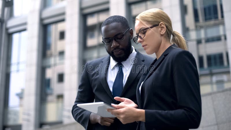 Colleagues developing business project and analyzing market on digital tablet stock photography