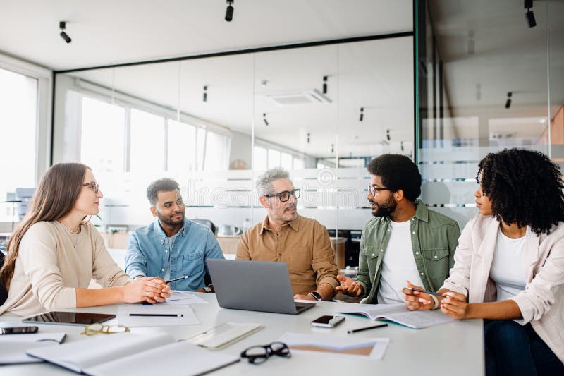 Colleagues engage in a lively exchange of ideas in an office stock photography