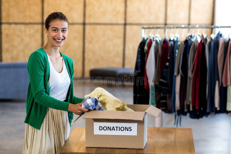 Portrait of colleagues sorting clothes from donation box in the office. Charity sorting stock images, royalty-free photos and pictures
