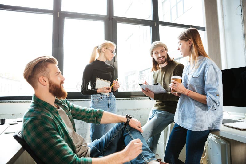 Colleagues Standing in Office and Talking with Each Other Stock Image