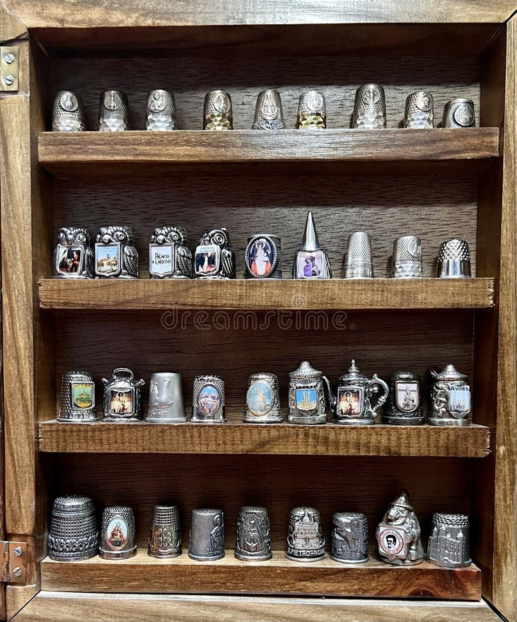 Collection of Thimbles in a Rustic Piece of Furniture. Stock Photo