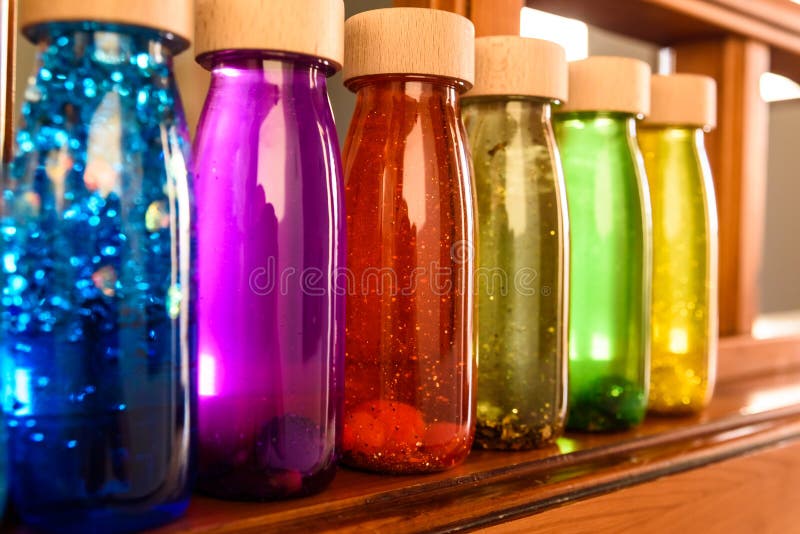 Collection of bottles of calm, plastic with wooden stopper, toy filled with liquids and materials of bright colors and glitter to