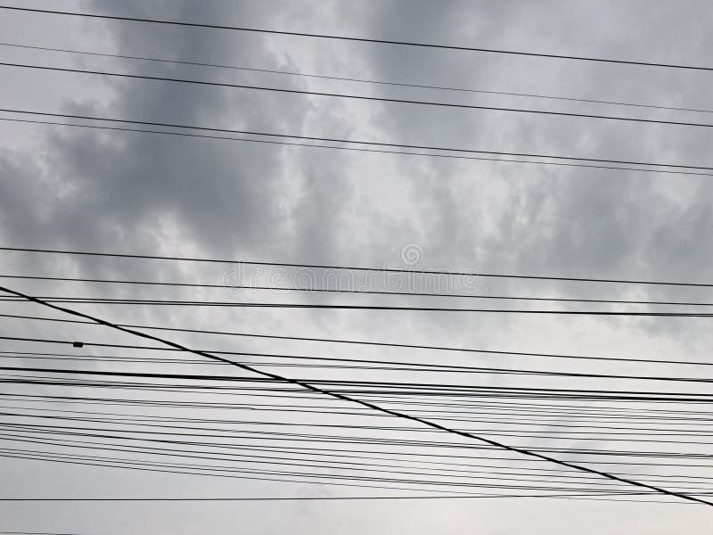A collection of electrical cables with a background of cloudy skies stock photography