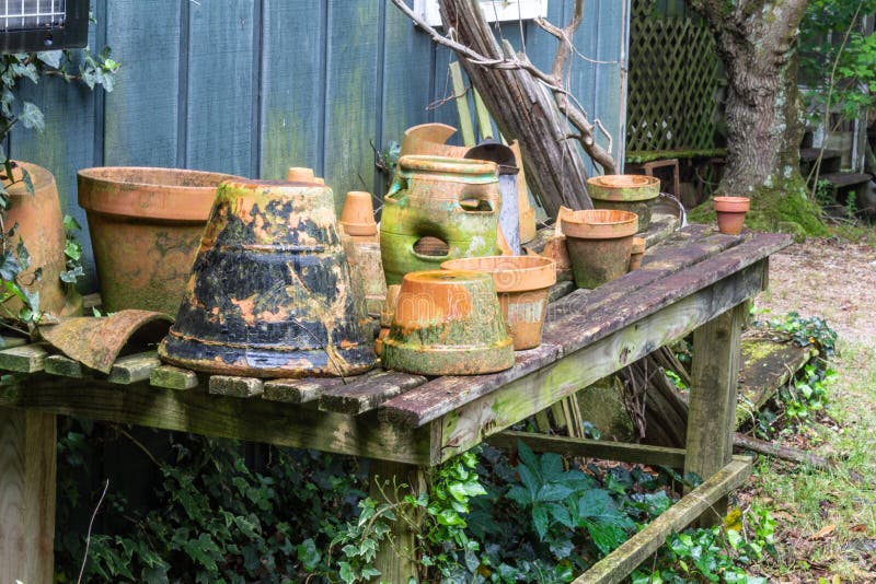 Collection of terra cotta pots on an open slat table stock images Collection of terra cotta pots on an open slat table stock images