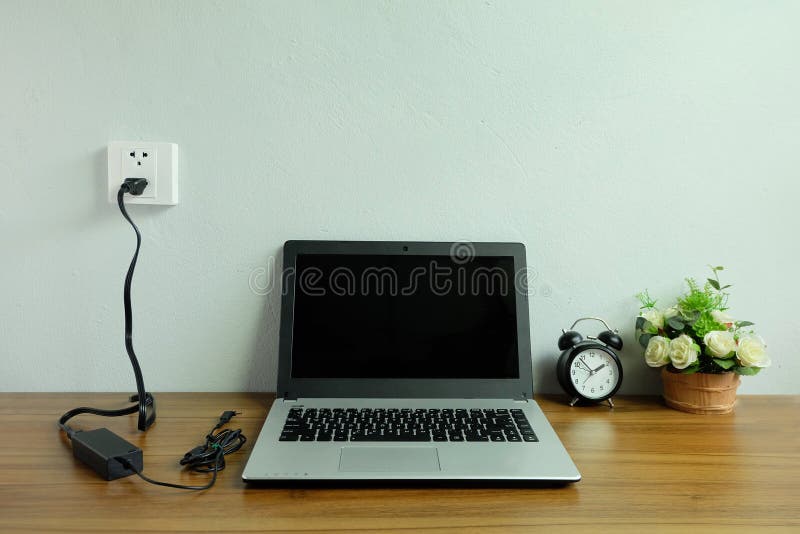 Collegare il caricatore del cavo dell'adattatore della presa di alimentazione alla parete bianca del computer portatile sul pavim immagini stock libere da diritti Collegare il caricatore del cavo dell'adattatore della presa di alimentazione alla parete bianca del computer portatile sul pavim immagini stock libere da diritti