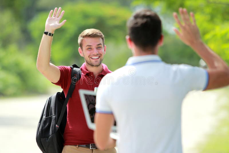 Portrait of handsome college student happy to meet his friend at college park and waving his hand. Portrait of handsome college student happy to meet his friend at college park and waving his hand