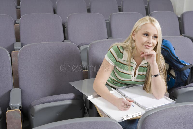 College Student Writing In Lecture Hall royalty free stock image College Student Writing In Lecture Hall royalty free stock image