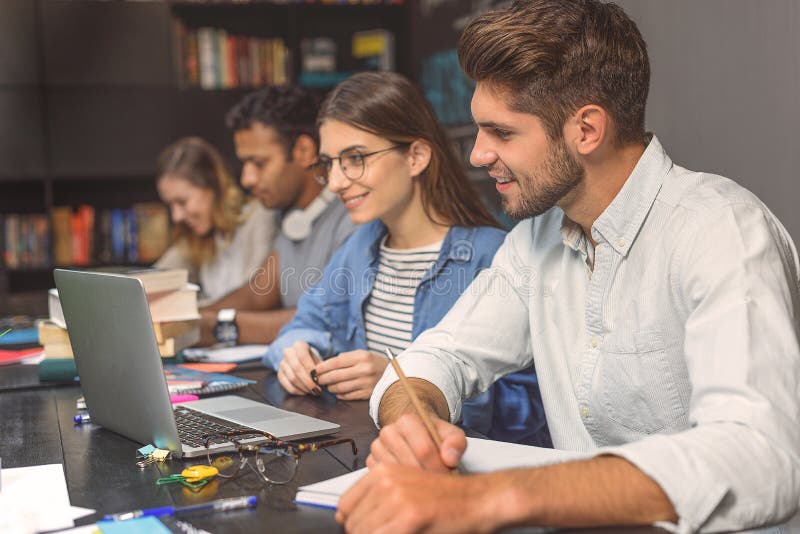 College students sitting together and studying stock photography