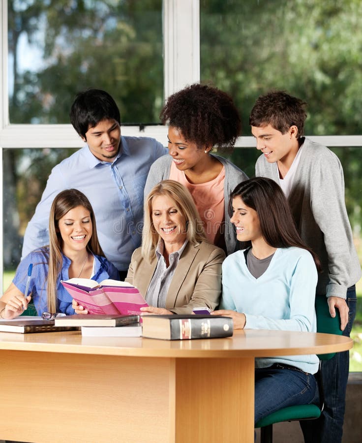 College Teacher Explaining Lesson To Students In stock photos