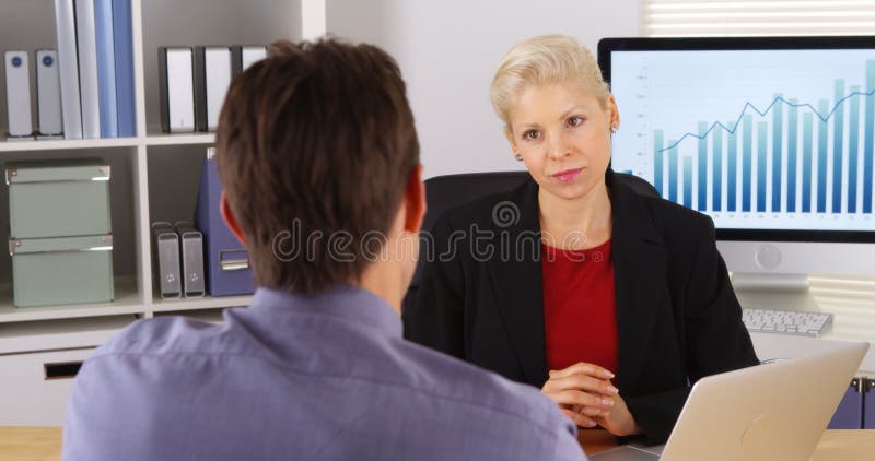 Colleghi di affari che parlano e che ascoltano nell'ufficio fotografie stock Colleghi di affari che parlano e che ascoltano nell'ufficio fotografie stock