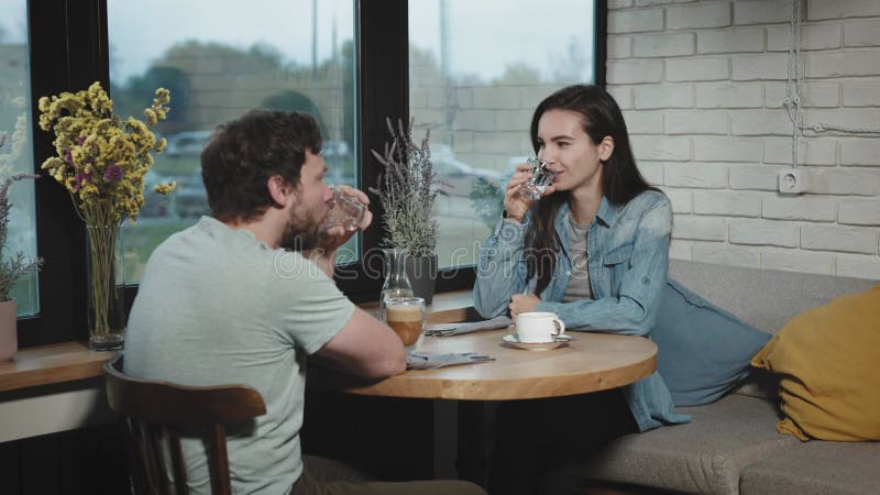 Colleghi di lavoro sono andati a mangiare qualcosa in un bar della città. un uomo e una donna stanno discutendo e aspettando la no stock footage
