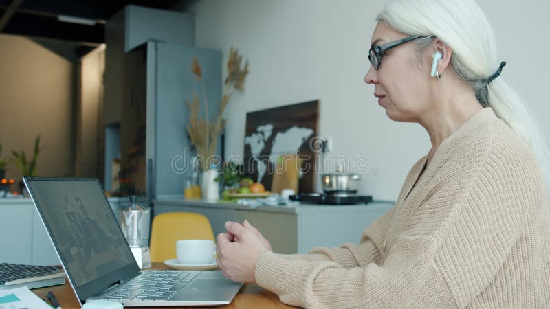 Colleghi e colleghi che fanno videochiamate online parlando e gestendo con laptop e auricolari a casa