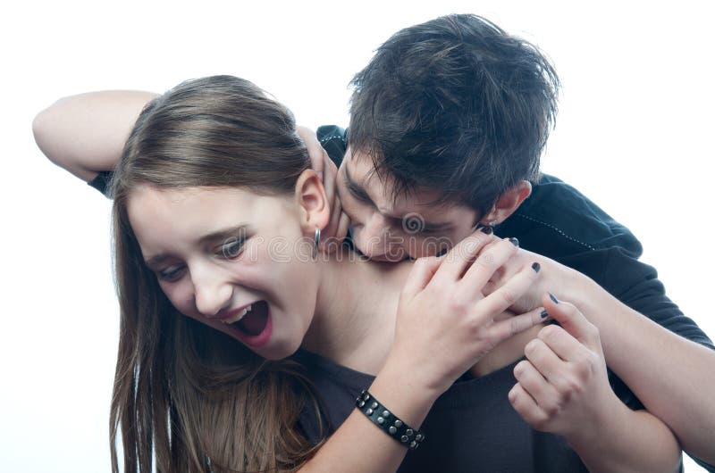 Vampire teenage boy biting neck of the frightened teenage girl that tries to defend herself. Vampire teenage boy biting neck of the frightened teenage girl that tries to defend herself.