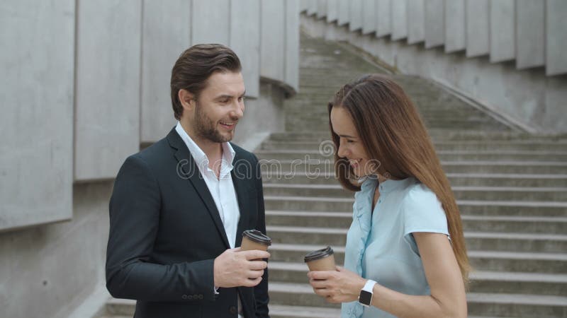 Collègues gay parlant dans la ville. Femme et homme ayant la réunion après le travail photographie stock