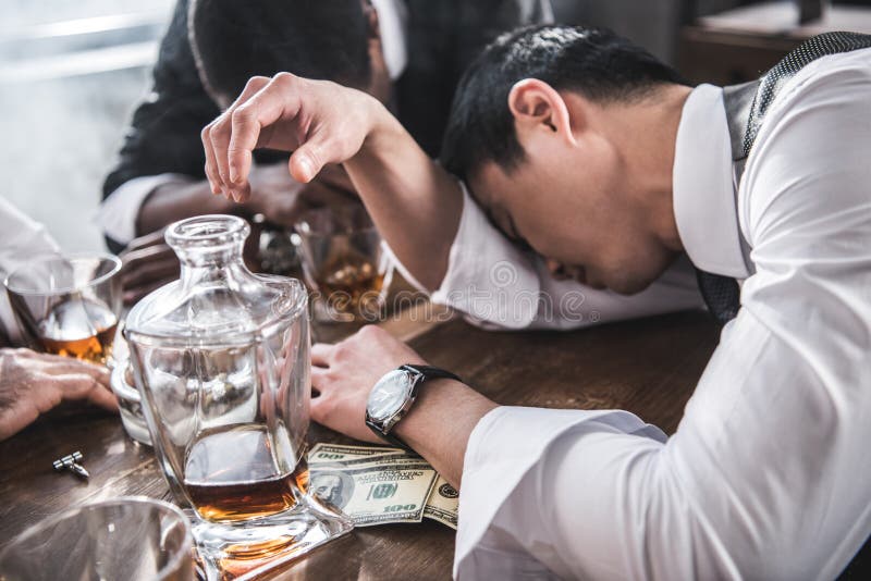 Collègues ivres dormant à la table tout en passant le temps ensemble après travail