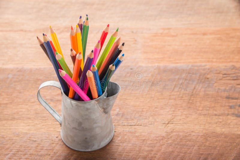 Color pencils in tin can, wood table background. education concept royalty free stock photo Color pencils in tin can, wood table background. education concept royalty free stock photo