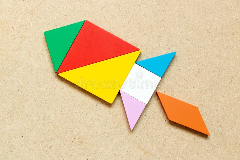 Color tangram in missile or rocket shape on wood background royalty free stock images