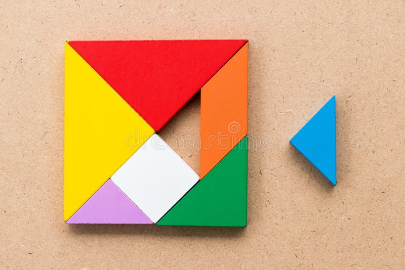 Color tangram puzzle in square shape that wait to fulfill on wood background