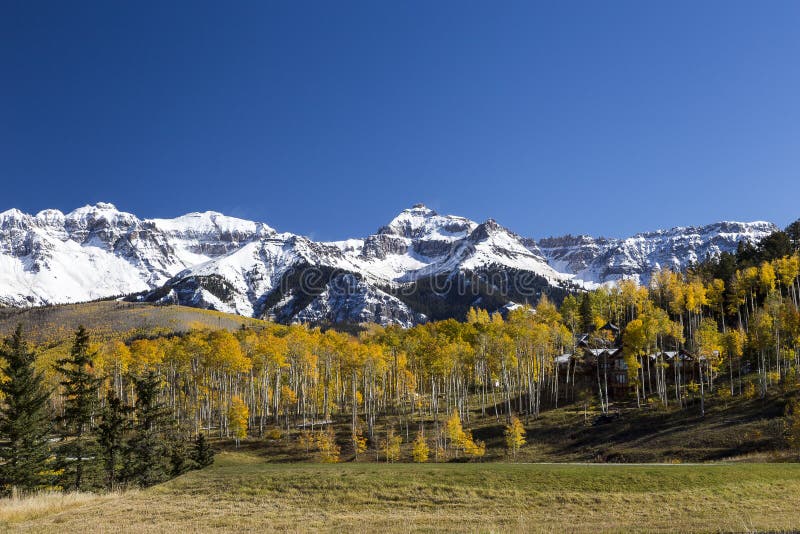Colorado landscape with large house nestled among colorful trees and snow peaked mountains. During bright sunny Fall day, USA royalty free stock images Colorado landscape with large house nestled among colorful trees and snow peaked mountains. During bright sunny Fall day, USA royalty free stock images