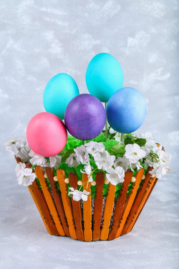 Colored Easter Eggs in a Basket on a Gray Concrete Background. Stock