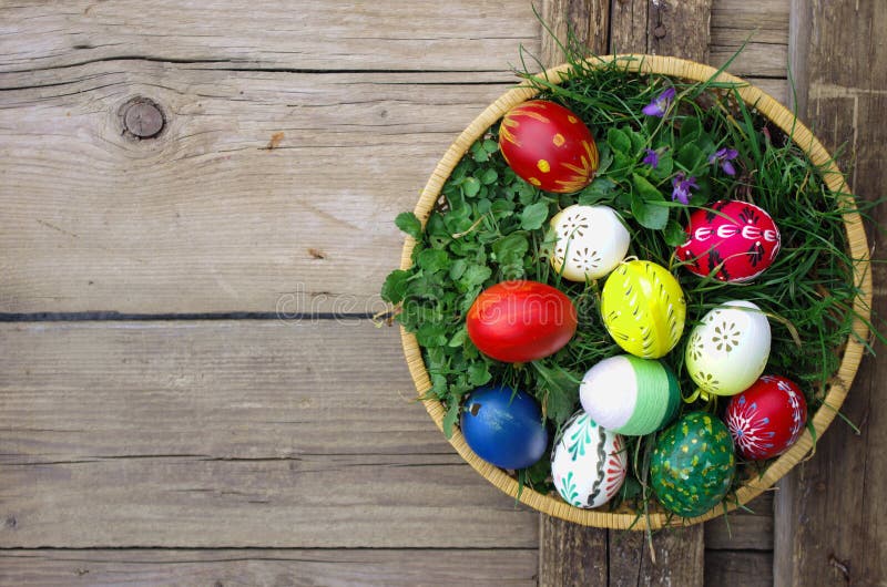 Barevná velikonoční vajíčka v košíku pohled shora na dřevěné pozadí. Veselé Velikonoce koncept karta. Veselé velikonoční vajíčka na dřevěné pozadí.