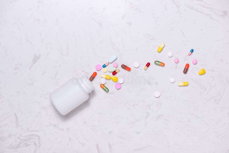 Colored pills with bottle on table. Flat lay.