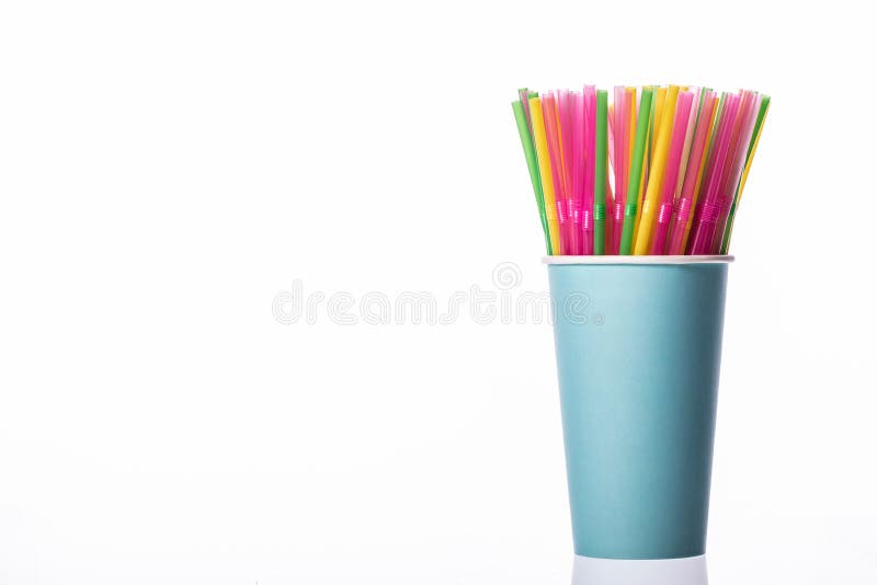 Colored plastic drinking straws in blue paper cup isolated on white background