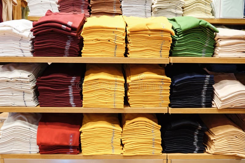 Variety of Colored Summer Shirts on the Shelf in the Store Stock Photo