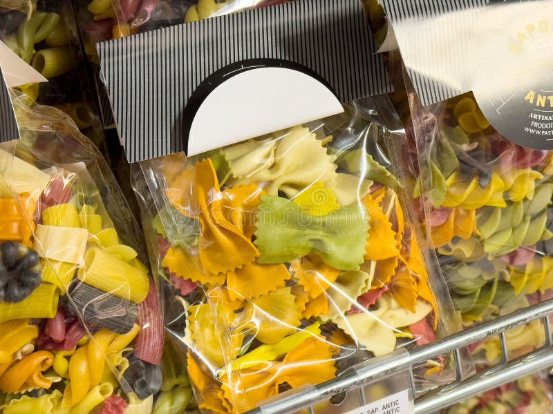 Colorful assorted pasta shapes displayed in clear packaging at grocery store fotografie stock