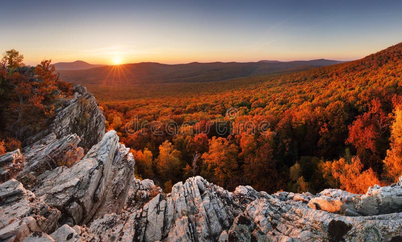 Barevné podzimní krajina v horách s červeným lesem, západ slunce
