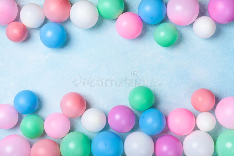 Colorful balloons frame on blue table top view. Festive or party background. Flat lay style. Birthday greeting card