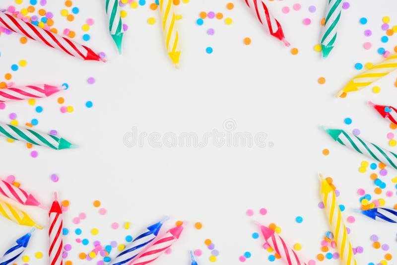 Colorful birthday cake candles with candy sprinkles. Top down view frame on a white background. Copy space. Colorful birthday cake candles with candy sprinkles. Top down view frame on a white background. Copy space