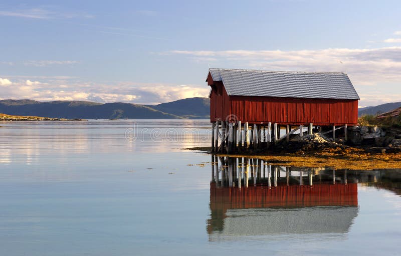 Colorful boat house reflected in the fjord waters
