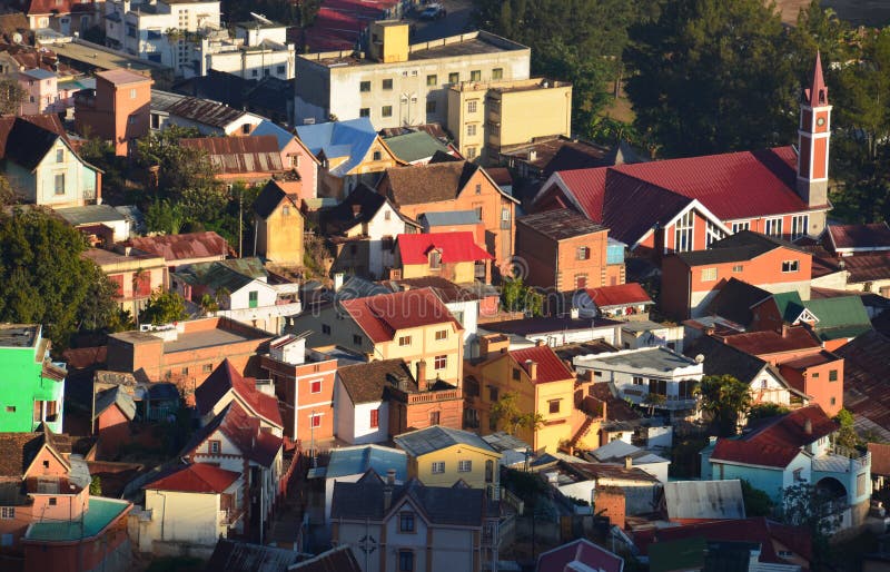 Colorful buildings and houses in Antananarivo, the capital city. View of Antananarivo, Madagascar from above, featuring an orange church with steeple and stock photography Colorful buildings and houses in Antananarivo, the capital city. View of Antananarivo, Madagascar from above, featuring an orange church with steeple and stock photography