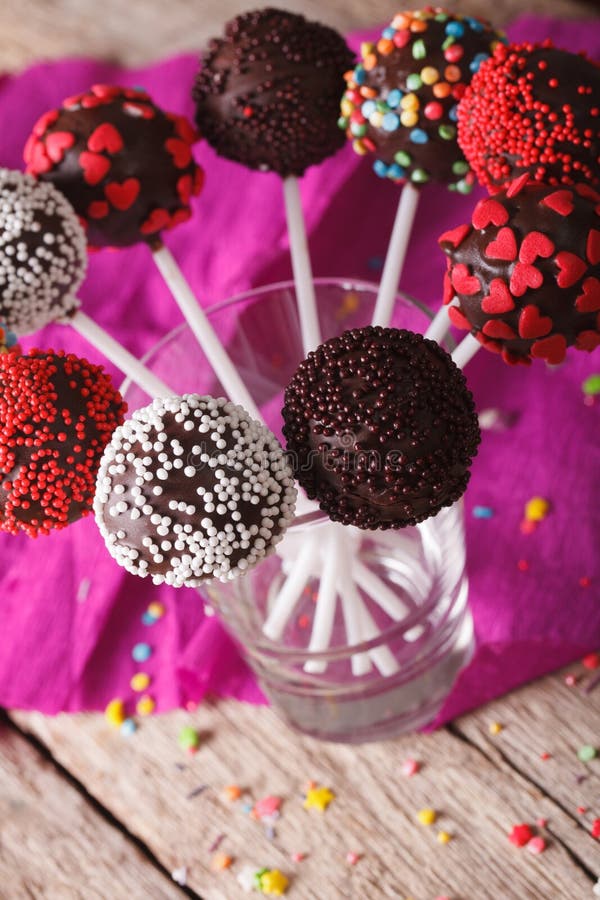 Colorful cake pops with candy sprinkles close up in a glass. ver