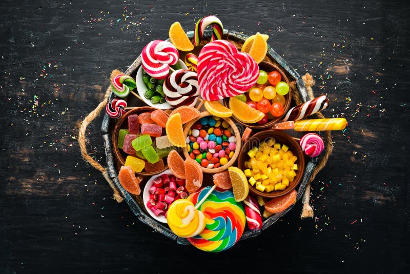 Colorful candies, jelly and marmalade in a wooden box. Sweets. On the old background. Top view.