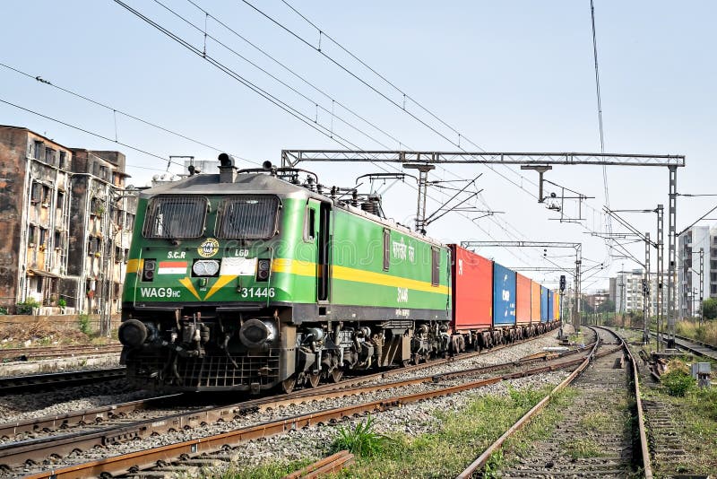 Tren pentru containere colorate cu locomotivă electrică de 9000CP care trece prin virar stock photo