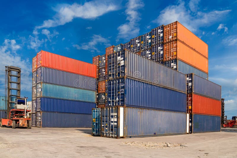 Colorful containers stacked at harbor freight terminal against blue sky background
