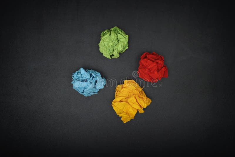 Colorful crumpled paper balls on a blackboard royalty free stock image