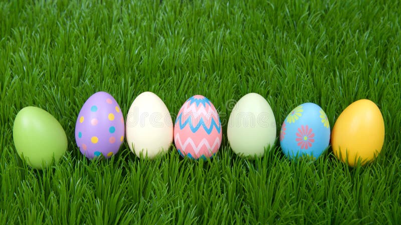 Colorful easter eggs in a row on green grass