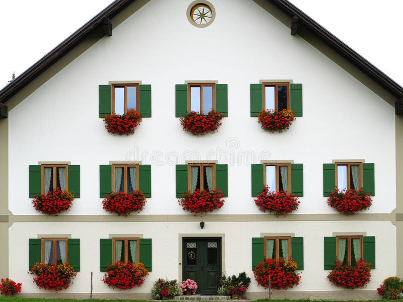 Decorative house facade with external window shutters and flower boxes
