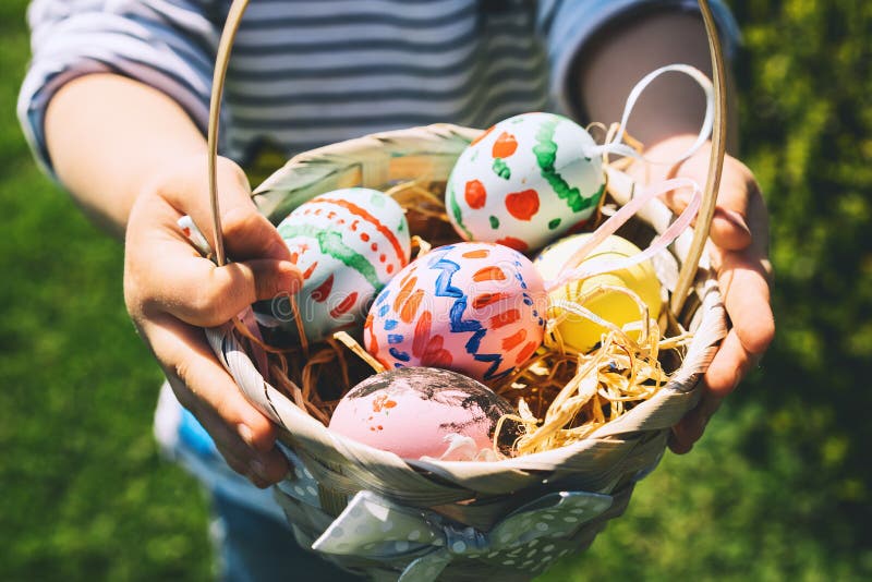 Colorful Easter eggs in basket. Kids hunt for eggs outdoors