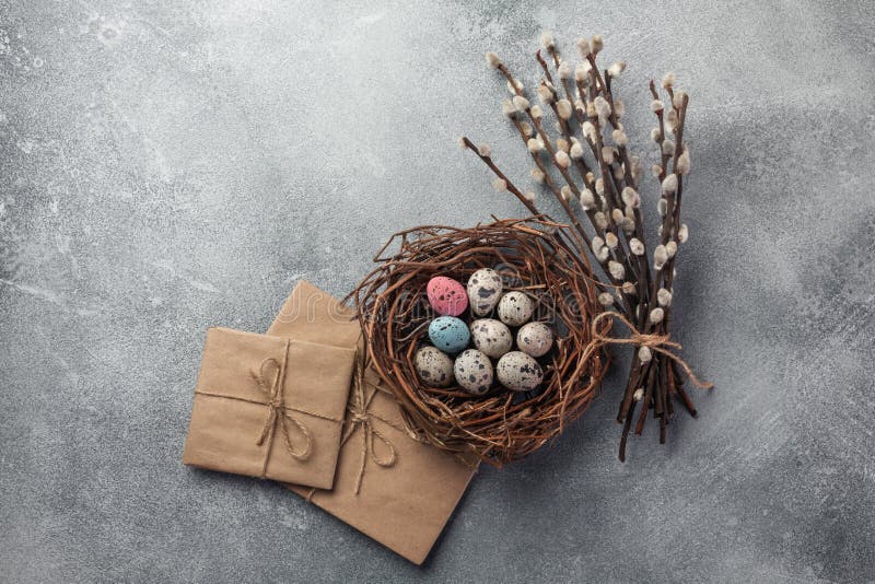 Colorful easter eggs in box and flowers on table. Top view with copy space