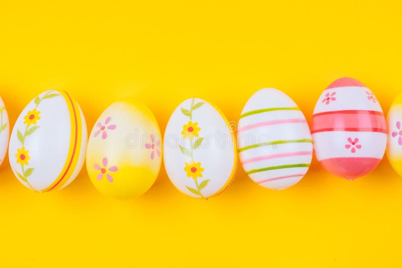 Colorful Easter Painted Eggs Background on Yellow Pastel Color